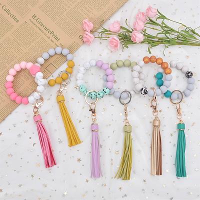 China New Daily Life Monogram Tassel Key Chain Silicone Bracelet Key Chain Silicone Wristband Pendant Wood Customization for sale