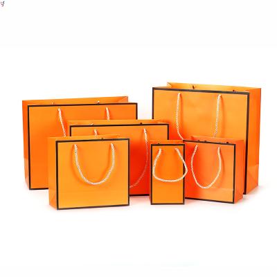 China Recyclable High End Shiny Orange Lipstick Cosmetic Clothes Luxury Custom Logo Printed Paper Shopping Gift Bags for sale