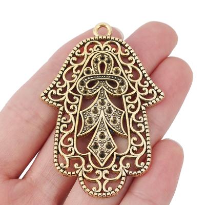 China FASHIONABLE Antique Gold Big Hollow Filigree Hamsa Hand Charms Pendants For Necklace Jewelry Making for sale