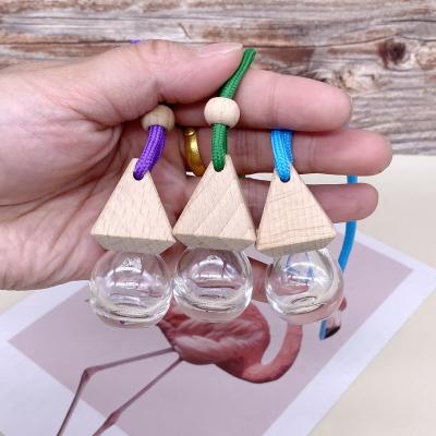 China Creative Air Freshener 5ml 8ml 10ml Triangle Cap Car Perfume Bottle Wooden Lid With Lanyard Empty Glass Perfume Bottle for sale