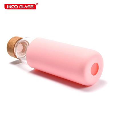 China Borosilicate glass sustainable eco designed pink water bottles with bamboo lid and silicone sleeve for sale