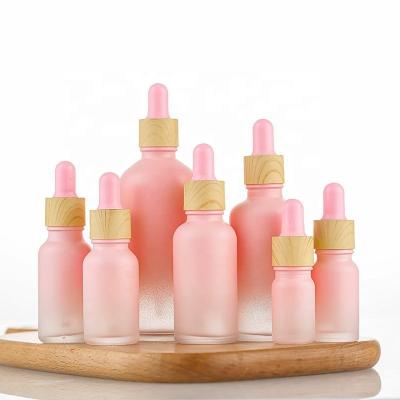 China Customized 15ml 20ml 30ml cosmetic serum gradient frosted pink essential oil bottle round glass bottle with dropper for sale