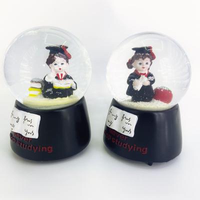 China Custom YIWU BAIWEN Folk Art Snow Globe Manufacturers Wholesale Promotional Promotional Fairy Snow Globe Graduation Snow Globe for sale