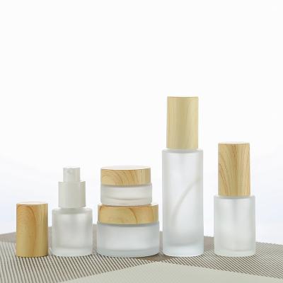 China Personal Care Help You Design Wooden Lid Frosted Round Cream Bottle Glass Cosmetic Sprayer Bottle for sale