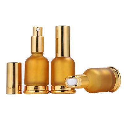 China Personal Skin Care Packaging Round Designer Amber Frosted Gold Thick Bottom Oin Glass Essential Bottle for sale