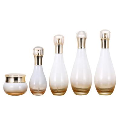 China Personal Care Made In China Luxury Look Bowling Shape Cosmetic Glass Bottles With Gold Lid For Lotion And Cream Package for sale