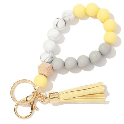 China Vintage In New Fashion Design Monogram Silicone Wood Beads Bracelet PU Tassel Metal Key Chain For Women And Lady Keychina for sale