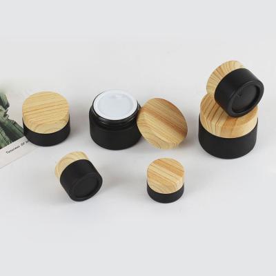 China Liner Face Cream Jar Skin Care Cosmetic Packaging Containers 20g 30g 50g Matte Black Black Cosmetic Jars With Grain Bamboo Lid Glass Jar for sale