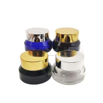 China Cosmetic Wholesale 15g slant shoulder clear blue amber green Glass cream jar bottle with rotating gold lid for sale