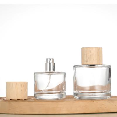 China 30ml 50ml 100ml Round Frosted Clear Glass Perfume Bottle with Wooden Cap for sale