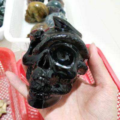 China Wholesale Natural Europe Obsidian Skulls With Serpent Crossing It Crystal Healing Skulls Crystal Carvings for sale