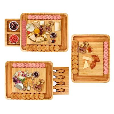 China Sustainable bamboo cheese board with two drawers for knives steak cheese cutting board and seasoning bowls for sale