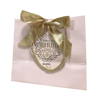 China Recyclable Customized Pink Paper Gift Bag Logo Printed Shopping Packaging Bag With Ribbon Handle for sale