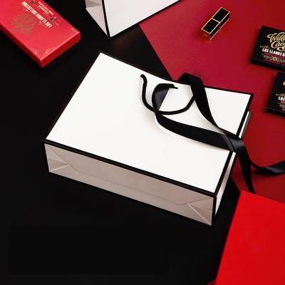 China Handmade Competitive Price Brand Luxury Boutique Shopping White Logo Gift Elegant Customized Paper Bags With Bowknot Ribbon Closure for sale