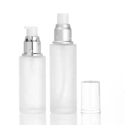 China Cosmetic Customized Luxury Glass Lotion Empty Bottles Container Glass Bottles With Press Pump Cap for sale