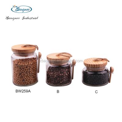 China Freshness Preservation Round Coffee Bean Kitchen Glass Storage Jar With Wooden Spoon for sale