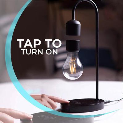 China Modern Creative Balanced Magnetic Levitation Floating Light Bulb Desk Night Lamp With Mobile Phone Wireless Charging Function for sale