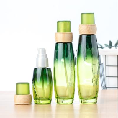 China Cosmetic Bottles 50g 40ml 100ml 120ml Green Glass Lotion Glass Bottle With Pump for sale