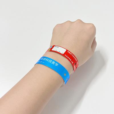 China Custom Promotion Gift Items Logo Vinyl PVC Wristbands L Shape One Layer PVC Waterproof Colorful Paper Wristband Bands en venta