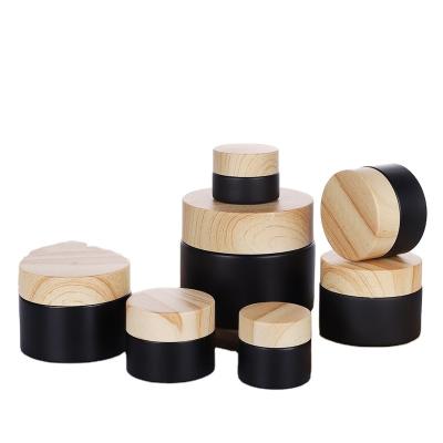 China Eco-friendly Wholesale 15g 30g 50g Black Glass Cosmetic Cream Jar With Wooden Lid for sale