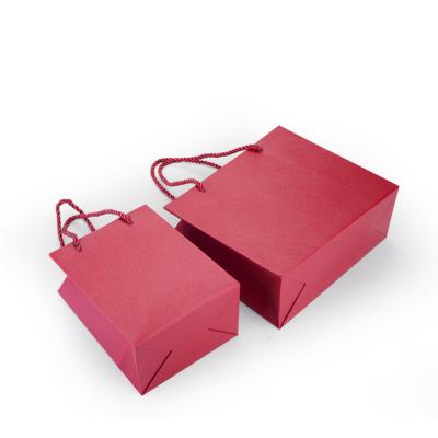 China High Quality Recycled Materials Shopping Paper Bags Packaging Embossed Red Black Paper Bag With Ribbon Handle for sale