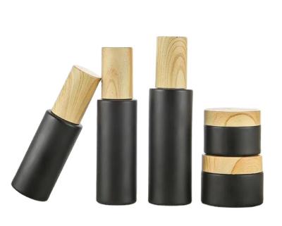 China Personal care 30g 50g spot round shape 5g empty refillable gel matte black glass cream jar with bamboo cap for sale