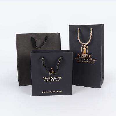 China New Logo Hot Foiled Stamping Black Matt Kraft Paper Bag With Gold Biodegradable Cotton Rope Handles for sale