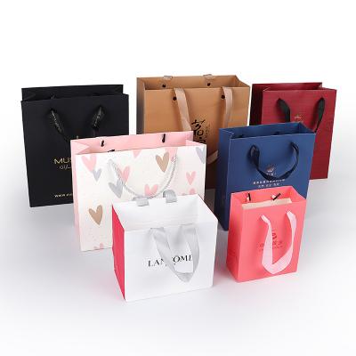 China Biodegradable Custom Luxury Garment Bag Packing Pink Bolsas De Papel Shopping Bag Gift Packaging Paper Bags With Handles For Clothes for sale