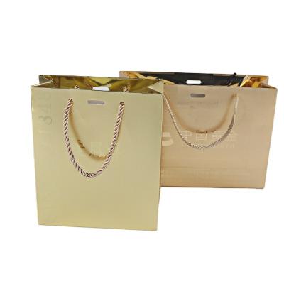 China Biodegradable custom logo high quality gold foil stamping matte shopping paper bag with paper ribbon handle bag en en venta