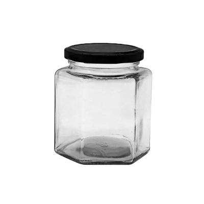 China 500ml food glass jars for honey clear hexagon with lids/making hexagon oval jar with metal lids for sale