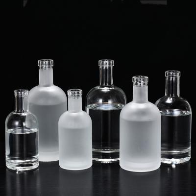 China Beverage factory 50ml 100ml clear round empty vodka glass bottle with caps for liquor beverage for sale