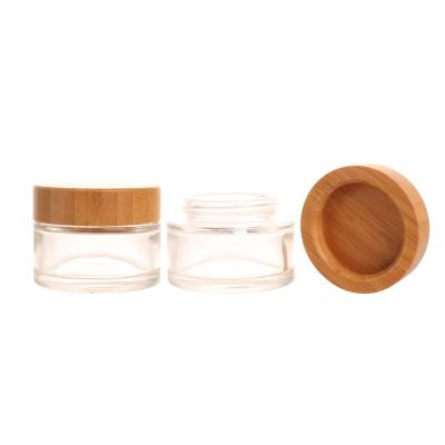 China Personal Skin Care Packaging 50ml Skin Care Face Cream Packaging Glass Cylinder Shape Clear Glass Bamboo Screw Lid Eco-friendly Jar Cream Glass Jar for sale