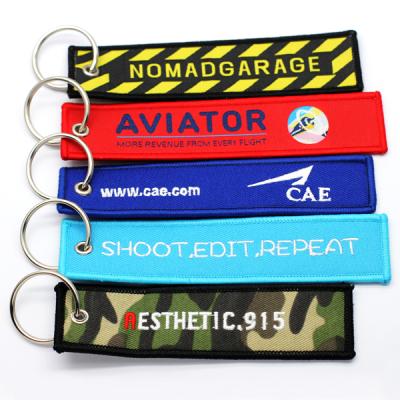 China Eco-friendly Promotional Wholesale Custom Souvenir Woven Embroidery Logo Fabric Brand Travel Keychains for sale