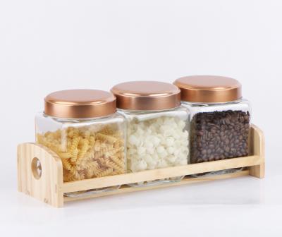 China CP218 800ml freshness preservation glass spice jar and candy jar with copper color lid and wooden stand for sale