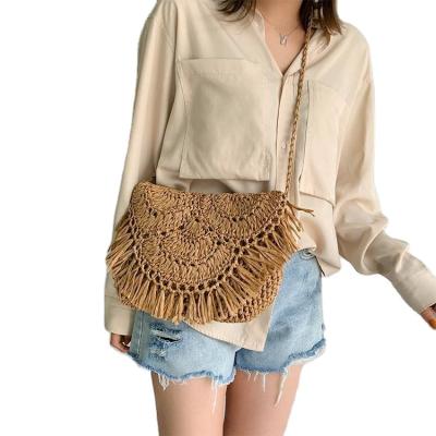 China Handmade Straw Lady Woven Shoulder Cross Tassel Handbags Women's Body Bag Small Tide Holiday Semicircle Cover Crocheted Sling Beach Bag for sale