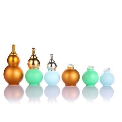 China New 10ml 20ml 30ml 50ml Pumpkin Glass Bottle Cosmetic Gold Clear Cap Fine Oil Bottle for sale