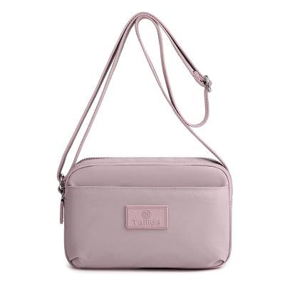 China Water-resistant ODM three-layer pull chain sling messenger bag new small printing ladies and girls one-shoulder mobile phone messenger bag for sale