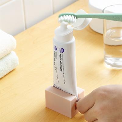 China Home Supply Plastic Easy Tooth Rolling Rack Dispenser Squeezer Tube Toothpaste Cleaning Accessories for sale