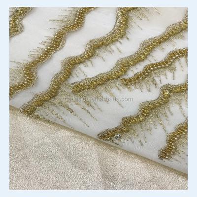 China Hottest Sustainable Stock Lace Fabrics Handmade Sequin Lace Fabric Beaded Embroidered For Dress Wedding for sale