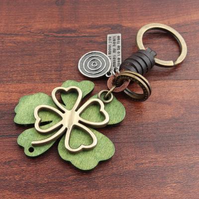 China Fashion Personalized Handmade Clover Wood Green Leather Metal Key Chain For Gifts for sale