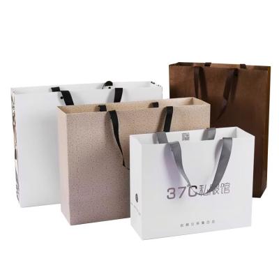 China Embalaje de bolsas de papel para ropa zapatos Logotipo personalizado Impreso Bolsas de papel de lujo en venta