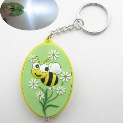 China Custom cute promotional gifts 3d cartoon figure bee anime shape logo design led pvc keychains with led flashlight function for sale