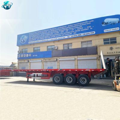 China Flat Bed Truck Trailer Manufacturer 3 Axles Cargo Container Hauling Flat Bed Semi Truck Trailer With Hydraulic End Plate for sale