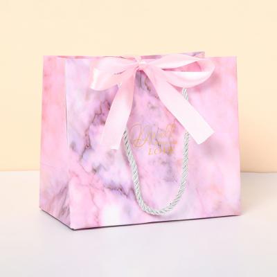 China Recycled Materials Gift Pink Color Small Wedding Cosmetic Paper Promotional Boutique Jewelry Bag Gift Paper Bags With Bow Tie Ribbon Handle for sale