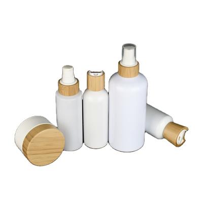 China Eco-friendly empty bamboo cosmetic packaging 50ml 60ml 100ml 120ml 250ml 500ml white plastic bottle with bamboo cap for sale