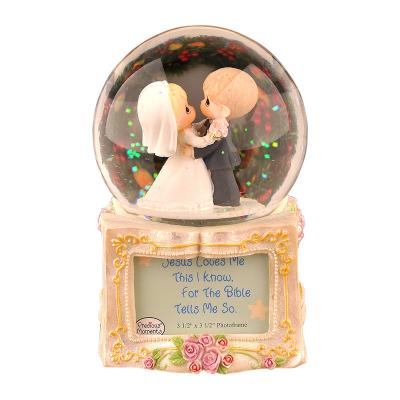 China Crystal Ball Merge With Sculpture Music Box Gift For Girlfriend Or WifeResin Wedding With Photo Frame Wedding Theme Water Snow Globe Music Box for sale