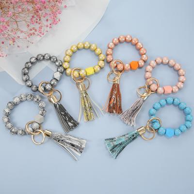 China Environmentally Friendly Bracelet Key Chain Key Ring Bracelet Wooden Beaded Wristlet Keychains With Leather Tassels for sale