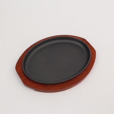 China Home Kitchen Cast Iron Oval Shape BBQ Grill Plate Hot Sizzling Steak Pan Plate With Wooden Base for sale