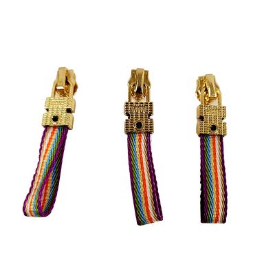 China Eco-friendly Zinc Alloy Rainbow Zipper Puller Nylon Webbing Ribbon Gold Plated Sliders Bag Shoes Zipper Pull Head for sale