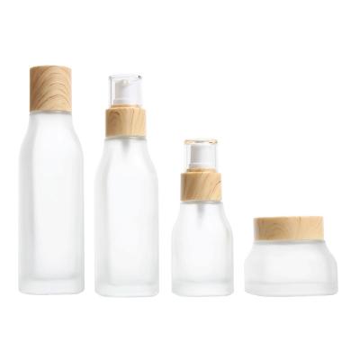 China Personal Care Empty Square Frosted 40ml 100ml 120ml Glass Cosmetic Bottle Set 50g Cream Glass Jar With Wood Grain Lid for sale